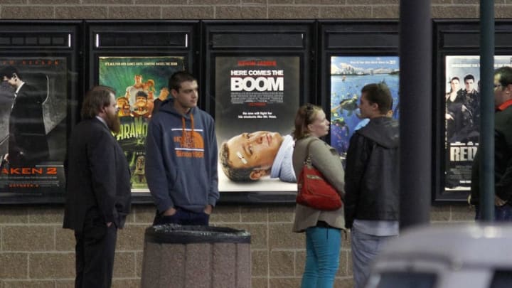AURORA, CO - JANUARY 17: Invited guests stand by a line of movie posters before making their way into a reopening ceremony for the Cinemark Century 16 Theaters on January 17, 2013 in Aurora, Colorado. The theater was the site of a mass shooting on July 20, 2012 that killed 12 people and wounded dozens of others. (Photo by Marc Piscotty/Getty Images)