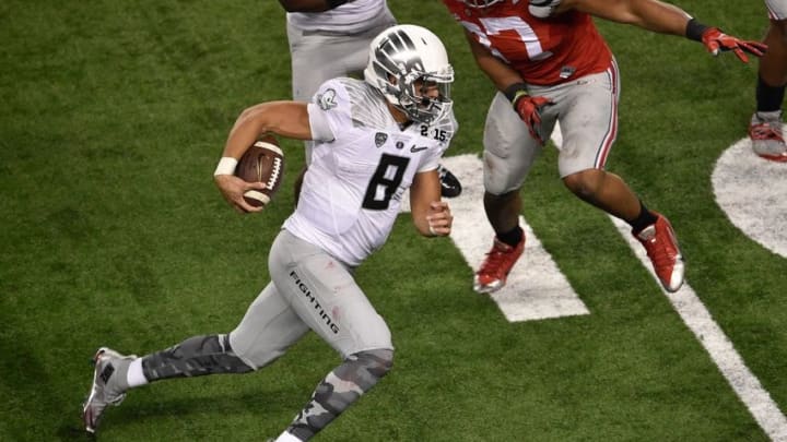 Jan 12, 2015; Arlington, TX, USA; Oregon Ducks quarterback Marcus Mariota (8) runs with the ball against the Ohio State Buckeyes during the game at AT&T Stadium. The Buckeyes defeated the Ducks 42-20. Mandatory Credit: Jerome Miron-USA TODAY Sports