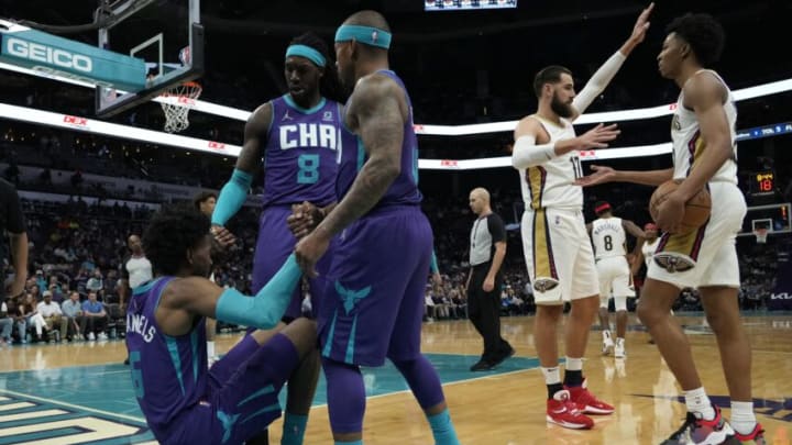 Mar 21, 2022; Charlotte, North Carolina, USA; Charlotte Hornets guard Isaiah Thomas (4) and center Montrezl Harrell (8) help forward Jalen McDaniels (6) to his feet during the second quarter against the New Orleans Pelicans at Spectrum Center. Mandatory Credit: Jim Dedmon-USA TODAY Sports