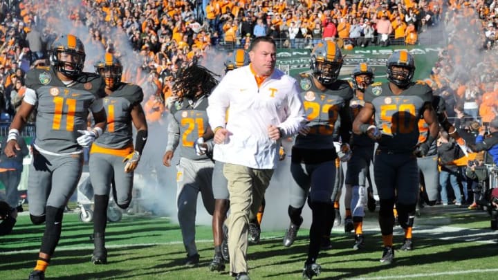 NASHVILLE, TN - DECEMBER 30: Head coach Butch Jones and quarterback Joshua Dobbs #11 rush out onto the field prior the Franklin American Mortgage Music City Bowl against the Nebraska Cornhuskers at Nissan Stadium on December 30, 2016 in Nashville, Tennessee. (Photo by Frederick Breedon/Getty Images)