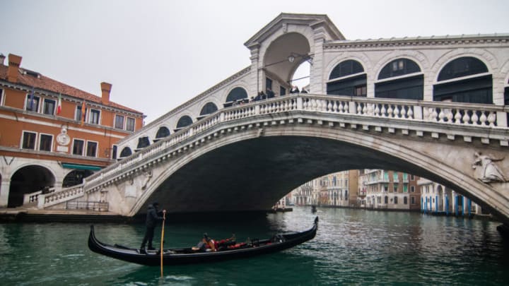 VENICE, ITALY - FEBRUARY 06: A gondola sails under the Rialto bridge on February 06, 2021 in Venice, Italy. Italy is still under restriction for the pandemic, and the 2021 The Venice Carnival is mainly being streamed, with just citizens and visitors from the Veneto region allowed to go to Venice. (Photo by Simone Padovani/Awakening/Getty Images)