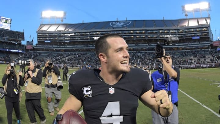 Nov 27, 2016; Oakland, CA, USA; Oakland Raiders quarterback Derek Carr (4) celebrates with game ball after a NFL football game against the Carolina Panthers at Oakland-Alameda County Coliseum. The Raiders defeated the Panthers 45-42. Mandatory Credit: Kirby Lee-USA TODAY Sports