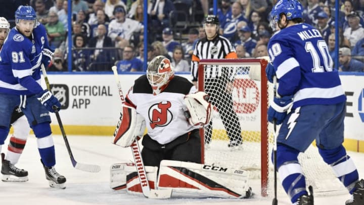 TAMPA, FL - APRIL 21: New Jersey Devils goalie Cory Schneider (35) makes a glove save while Tampa Bay Lightning center Steven Stamkos (91) and Tampa Bay Lightning center J.T. Miller (10) look for a rebound during the second period of an NHL Stanley Cup Eastern Conference Playoffs between the New Jersey Devils and the Tampa Bay Lightning on April 21, 2018, at Amalie Arena in Tampa, FL. (Photo by Roy K. Miller/Icon Sportswire via Getty Images)