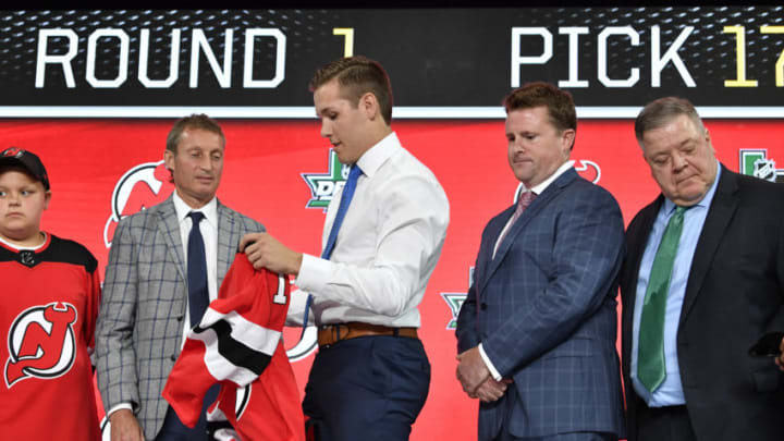 Jun 22, 2018; Dallas, TX, USA; Ty Smith puts on a team jersey after being selected as the number seventeen overall pick to the New Jersey Devils in the first round of the 2018 NHL Draft at American Airlines Center. Mandatory Credit: Jerome Miron-USA TODAY Sports