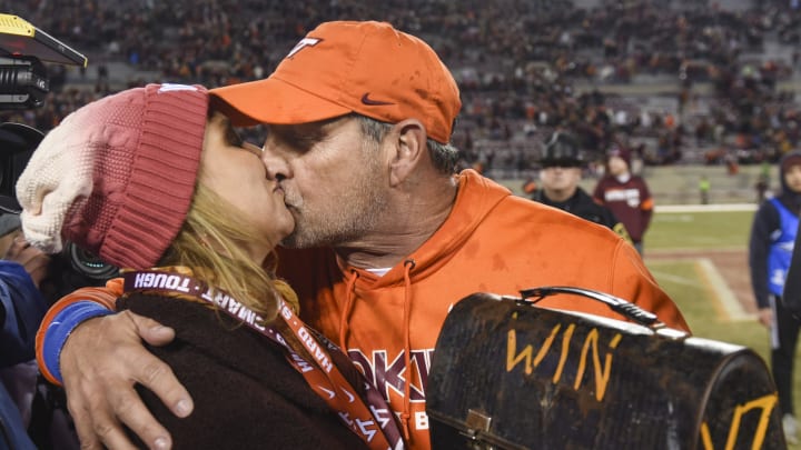 BLACKSBURG, VA – NOVEMBER 9: Defensive coordinator and associate head coach Bud Foster of the Virginia Tech Hokies kisses his wife Jessie following the victory against the Wake Forest Demon Deacons at Lane Stadium on November 9, 2019 in Blacksburg, Virginia. (Photo by Michael Shroyer/Getty Images)