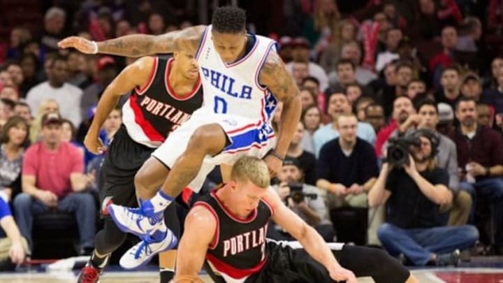 Jan 16, 2016; Philadelphia, PA, USA; Philadelphia 76ers guard Isaiah Canaan (0) leaps over Portland Trail Blazers center Mason Plumlee (24) to pick up a loose ball during the second half at Wells Fargo Center. The Philadelphia 76ers won 114-89. Mandatory Credit: Bill Streicher-USA TODAY Sports