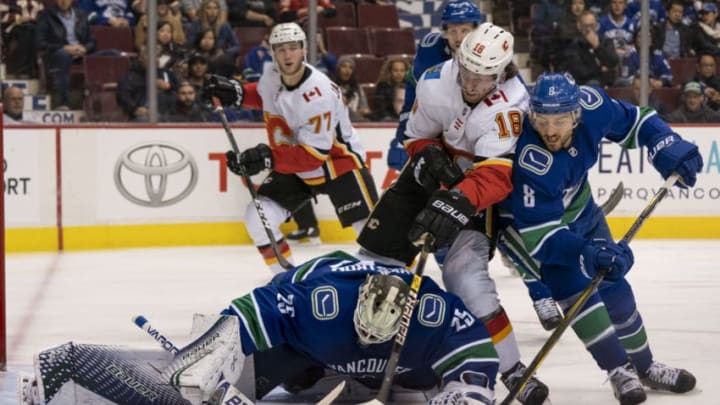 VANCOUVER, BC - OCTOBER 3: Goalie Jacob Markstrom #25 of the Vancouver Canucks looks to cover up the loose puck while James Neal #18 of the Calgary Flames and Chris Tanev #8 of the Canucks battle in NHL action on October, 3, 2018 at Rogers Arena in Vancouver, British Columbia, Canada. (Photo by Rich Lam/Getty Images)