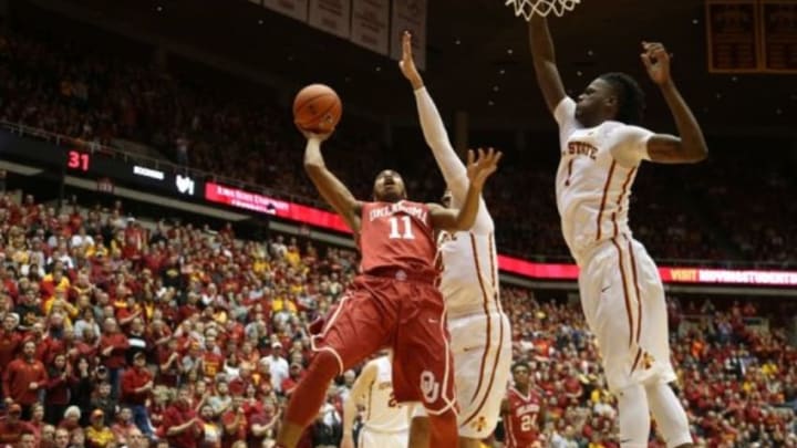 Jan 18, 2016; Ames, IA, USA; Oklahoma Sooners guard Isaiah Cousins (11) splits the defense of Iowa State Cyclones forward Abdel Nader (2) and forward Jameel McKay (1) at James H. Hilton Coliseum. Mandatory Credit: Reese Strickland-USA TODAY Sports