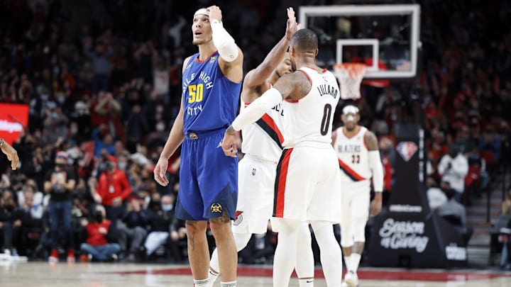 Nov 23, 2021; Portland, Oregon, USA; Portland Trail Blazers point guard Damian Lillard (0) celebrates with teammate CJ McCollum (3, behind) after a basket as Denver Nuggets power forward Aaron Gordon (50) reacts during the first half at Moda Center. Mandatory Credit: Soobum Im-USA TODAY Sports Nov 23, 2021; Portland, Oregon, USA; Portland Trail Blazers point guard Damian Lillard (0) celebrates with teammate CJ McCollum (3, behind) after a basket as Denver Nuggets power forward Aaron Gordon (50) reacts during the first half at Moda Center. Mandatory Credit: Soobum Im-USA TODAY Sports