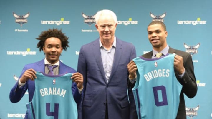 Charlotte Hornets Devonte’ Graham, left, and Miles Bridges, right, hold up their jerseys with President of Basketball Operations & General Manager Mitch Kupchak during an introductory news conference at Spectrum Center in Charlotte, N.C., on Friday, June 22, 2018. (David T. Foster III/Charlotte Observer/TNS via Getty Images)