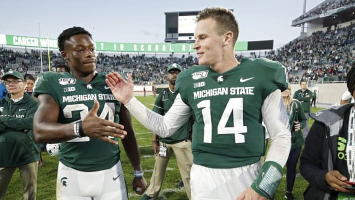 EAST LANSING, MI - SEPTEMBER 28: Brian Lewerke #14 and Elijah Collins #24 of the Michigan State Spartans celebrate after the game against the Indiana Hoosiers at Spartan Stadium on September 28, 2019 in East Lansing, Michigan. Michigan State defeated Indiana 40-31. (Photo by Joe Robbins/Getty Images)