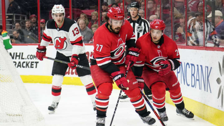 RALEIGH, NC - APRIL 04: Carolina Hurricanes Defenceman Justin Faulk (27) and Carolina Hurricanes Center Sebastian Aho (20) chase down a loose puck during a game between the New Jersey Devils and the Carolina Hurricanes at the PNC Arena in Raleigh, NC on April 4, 2019. (Photo by Greg Thompson/Icon Sportswire via Getty Images)