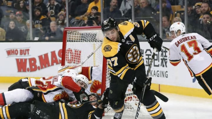 BOSTON, MA - FEBRUARY 13: Boston Bruins center Patrice Bergeron (37) tries to latch onto the puck with a pile in the crease during a game between the Boston Bruins and the Calgary Flames on February 13, 2018, at TD Garden in Boston, Massachusetts. The Bruins defeated the Flames 5-2. (Photo by Fred Kfoury III/Icon Sportswire via Getty Images)