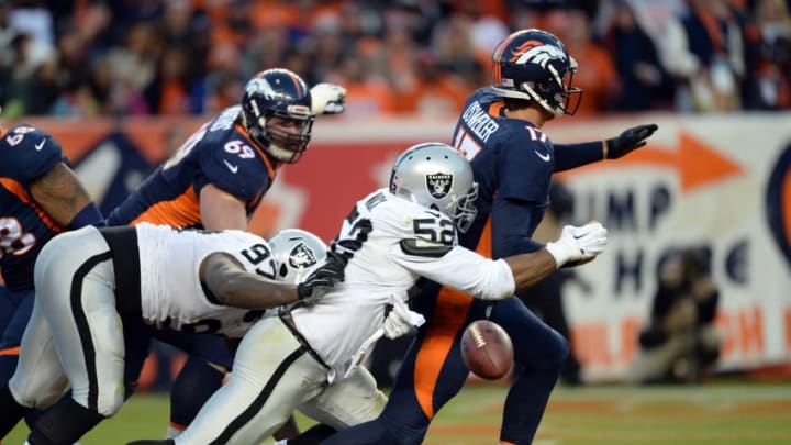 Dec 13, 2015; Denver, CO, USA; Oakland Raiders defensive end Khalil Mack (52) strip sacks Denver Broncos quarterback Brock Osweiler (17) in the end zone in the third quarter at Sports Authority Field at Mile High. Mandatory Credit: Ron Chenoy-USA TODAY Sports