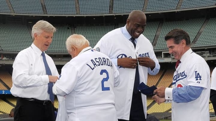 Los Angeles, CA, USA; Tommy Lasorda presents a jersey to Mark Walter as Steve Garvey gives a jersey to Magic Johnson at a press conference to announce their sale of the Los Angeles Dodgers to the Guggenheim baseball management team at Dodger Stadium. Mandatory Credit: Kirby Lee/Image of Sport-USA TODAY Sports
