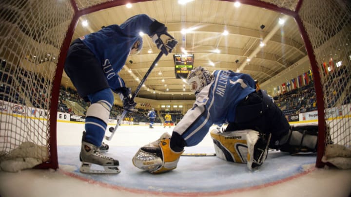 THIEF RIVER FALLS, MN - DECEMBER 29: Goaltender Joonas Hallikainen #1 of team Finland reaches to make a save while getting help from a teammate against team Sweden during the preliminary game at the World Junior Hockey Championships at the Ralph Engelstad Arena December 29, 2004 in Thief River Falls, Minnesota. (Photo by Jeff Vinnick/Getty Images)