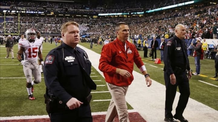 Dec 7, 2013; Indianapolis, IN, USA; Ohio State Buckeyes coach Urban Meyer walks off the field dejected after losing to the Michigan State Spartans in the Big 10 Championship game at Lucas Oil Stadium. Michigan State defeats Ohio State 34-24. Mandatory Credit: Brian Spurlock-USA TODAY Sports