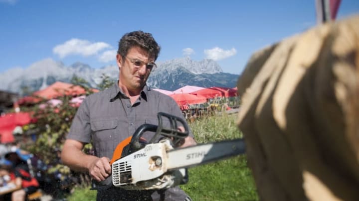 ELLMAU, AUSTRIA - SEPTEMBER 17: German actor Hans Sigl carves wood with a chainsaw as he visits the filming location of German-Austrian tv serie 'Der Bergdoktor' on September 17, 2011 in Ellmau, Austria. (Photo by Martin Hangen/Getty Images)