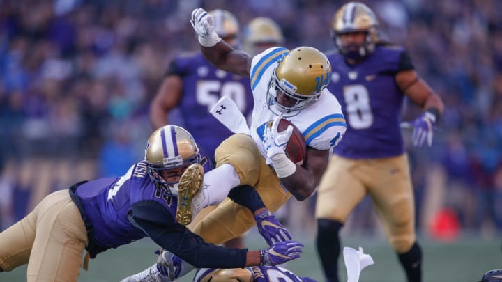 SEATTLE, WA – OCTOBER 28: Running back Bolu Olorunfunmi #4 of the UCLA Bruins rushes against defensive back Jojo McIntosh #14 (L) and defensive back Taylor Rapp #21 of the Washington Huskies at Husky Stadium on October 28, 2017 in Seattle, Washington. (Photo by Otto Greule Jr/Getty Images)