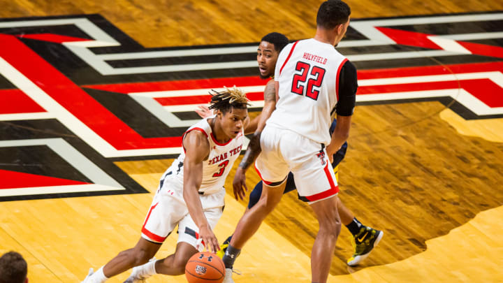 Guard Jahmi’us Ramsey #3 of the Texas Tech Red Raiders dribbles around a screen set by forward TJ Holyfield #22  (Photo by John E. Moore III/Getty Images)