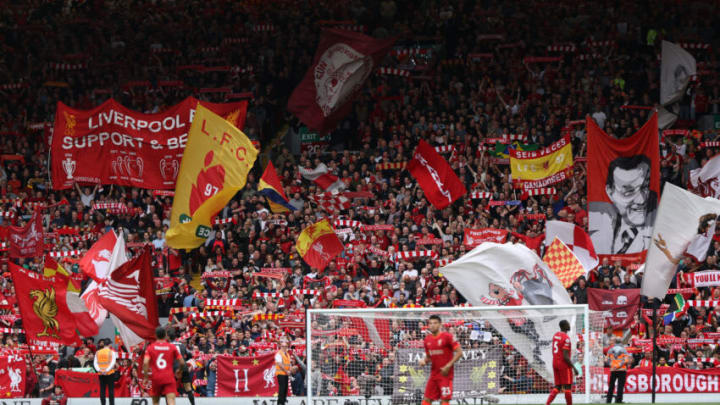 LIVERPOOL, ENGLAND - MAY 22: Liverpool fans wave flags in the crowd in The Kop before the Premier League match between Liverpool and Wolverhampton Wanderers at Anfield on May 22, 2022 in Liverpool, United Kingdom. (Photo by Matthew Ashton - AMA/Getty Images)