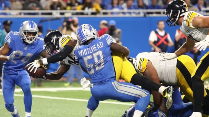 Le'Veon Bell dives over the goal line for a touchdown against Nevin Lawson of the Detroit Lions and Tahir Whitehead.
