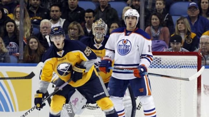 Nov 7, 2014; Buffalo, NY, USA; Edmonton Oilers right wing Nail Yakupov (10) screens Buffalo Sabres goalie Michal Neuvirth (34) as defenseman Rasmus Ristolainen (55) defends during the second period at First Niagara Center. Mandatory Credit: Kevin Hoffman-USA TODAY Sports