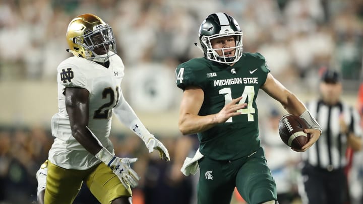 EAST LANSING, MI – SEPTEMBER 23: Brian Lewerke #14 of the Michigan State Spartans runs for a long gain during the first quarter as Jalen Elliott #21 of the Notre Dame Fighting Irish gives chase during the game at Spartan Stadium on September 23, 2017 in East Lansing, Michigan. (Photo by Leon Halip/Getty Images)
