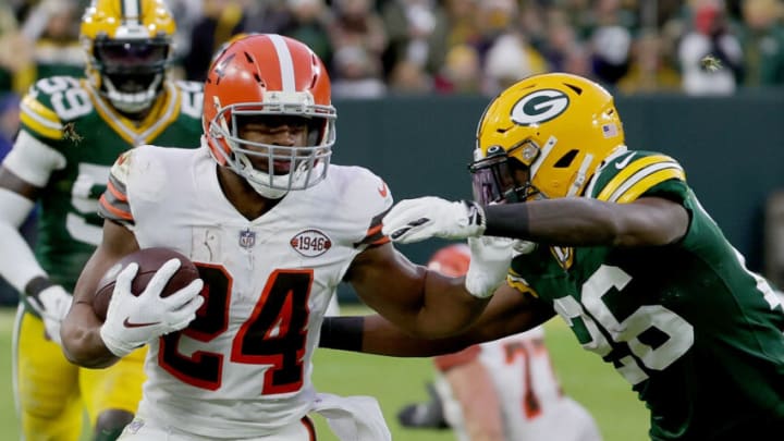 GREEN BAY, WISCONSIN - DECEMBER 25: Nick Chubb #24 of the Cleveland Browns runs with the ball while being chased by Darnell Savage #26 of the Green Bay Packers in the first quarter at Lambeau Field on December 25, 2021 in Green Bay, Wisconsin. (Photo by Stacy Revere/Getty Images)