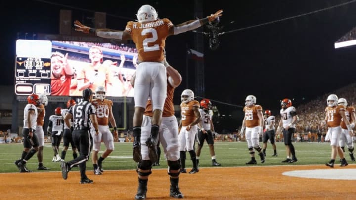 AUSTIN, TX - SEPTEMBER 21: Zach Shackelford #56 of the Texas Longhorns lifts Roschon Johnson #2 in celebration after scoring on a two point conversion against the Oklahoma State Cowboys in the fourth quarter at Darrell K Royal-Texas Memorial Stadium on September 21, 2019 in Austin, Texas. (Photo by Tim Warner/Getty Images)