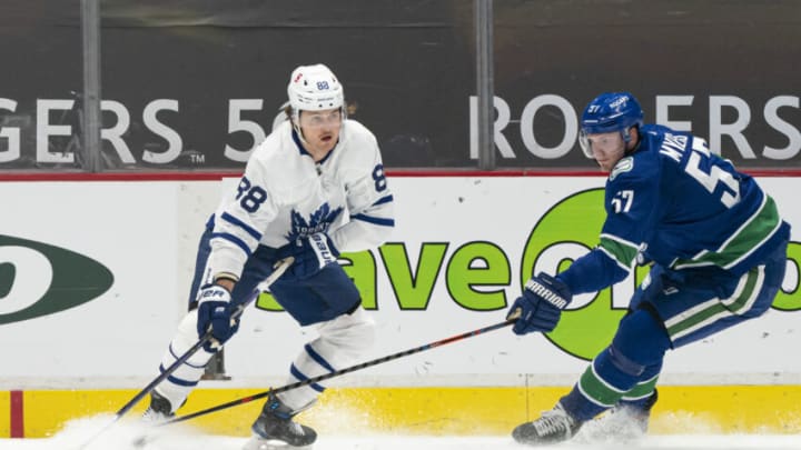 VANCOUVER, BC - APRIL 18: William Nylander #88 of the Toronto Maple Leafs looks to make a pass while pressured by Tyler Myers #57 of the Vancouver Canucks during NHL hockey action at Rogers Arena on April 17, 2021 in Vancouver, Canada. (Photo by Rich Lam/Getty Images)