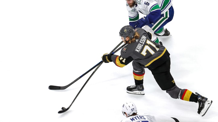 William Karlsson #71 of the Vegas Golden Knights attempts a shot under pressure from Oscar Fantenberg #5 of the Vancouver Canucks