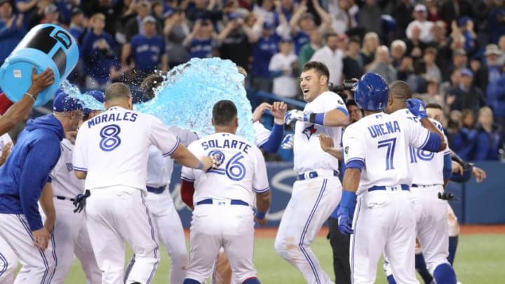 TORONTO, ON - MAY 11: Luke Maile #21 of the Toronto Blue Jays is congratulated at home plate by teammates after hitting a game-winning two-run home run in the twelfth inning during MLB game action against the Boston Red Sox at Rogers Centre on May 11, 2018 in Toronto, Canada. (Photo by Tom Szczerbowski/Getty Images)