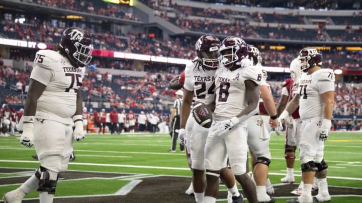 Sep 30, 2023; Arlington, Texas, USA; Texas A&M Aggies offensive lineman Kam Dewberry (75) and running back Earnest Crownover (24) and running back Le'Veon Moss (8) celebrate during the second half against the Arkansas Razorbacks at AT&T Stadium. Mandatory Credit: Jerome Miron-USA TODAY Sports