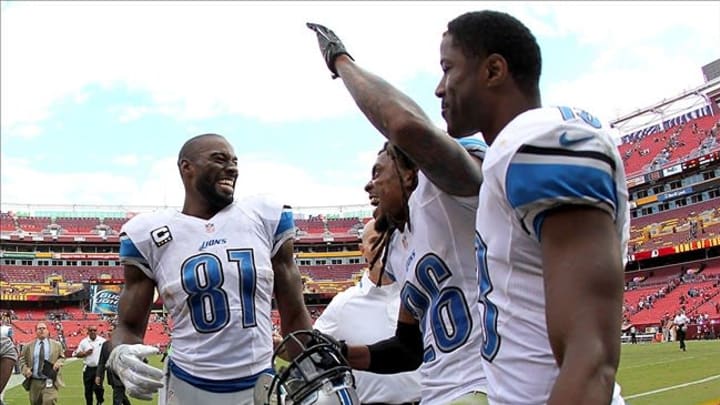 Sep 22, 2013; Landover, MD, USA; Detroit Lions wide receiver Calvin Johnson (81) celebrates with free safety Louis Delmas (26) and wide receiver Nate Burleson (13) after their game against the Washington Redskins at FedEx Field. The Lions won 27-20. Mandatory Credit: Geoff Burke-USA TODAY Sports