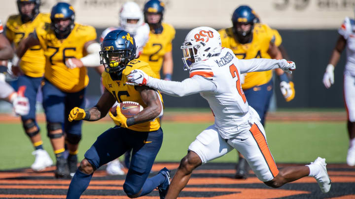 Sep 26, 2020; Stillwater, Oklahoma, USA; West Virginia Mountaineers wide receiver Winston Wright Jr. (16) runs the ball while defended by Oklahoma State Cowboys safety Tanner McCalister (2) during the first half at Boone Pickens Stadium. Mandatory Credit: Rob Ferguson-USA TODAY Sports