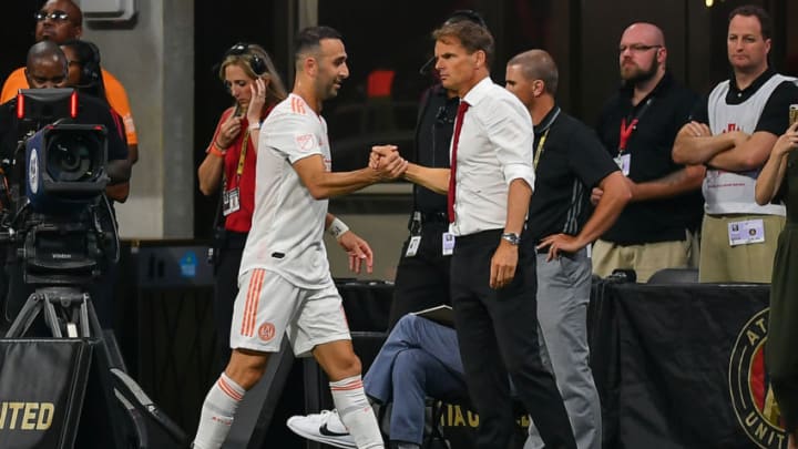 ATLANTA, GA JUNE 29: Atlanta's Justin Meram (14) is congratulated by head coach Frank de Boer (right) after being subbed off during the MLS match between the Montreal Impact and Atlanta United FC June 29th, 2019 at Mercedes Benz Stadium in Atlanta, GA. (Photo by Rich von Biberstein/Icon Sportswire via Getty Images)