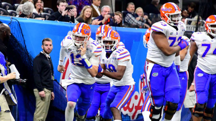 ATLANTA, GEORGIA - DECEMBER 29: Feleipe Franks #13 of the Florida Gators is congratulated by his teammates after his second quarter rushing touchdown against the Michigan Wolverines during the Chick-fil-A Peach Bowl at Mercedes-Benz Stadium on December 29, 2018 in Atlanta, Georgia. (Photo by Scott Cunningham/Getty Images)