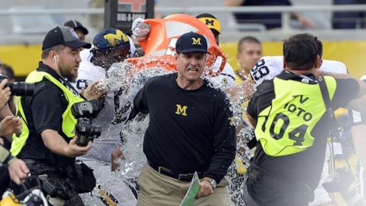Jan 1, 2016; Orlando, FL, USA; Michigan Wolverines head coach Jim Harbaugh has water dumped on him after defeating Florida Gators to 41-7 to win the 2016 Citrus Bowl at Orlando Citrus Bowl Stadium. Michigan Wolverines defeated Florida Gators 41-7. Mandatory Credit: Tommy Gilligan-USA TODAY Sports