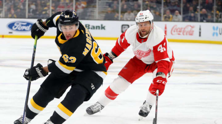 BOSTON, MASSACHUSETTS - FEBRUARY 15: Brad Marchand #63 of the Boston Bruins skates against Luke Glendening #41 of the Detroit Red Wings during the first period at TD Garden on February 15, 2020 in Boston, Massachusetts. (Photo by Maddie Meyer/Getty Images)