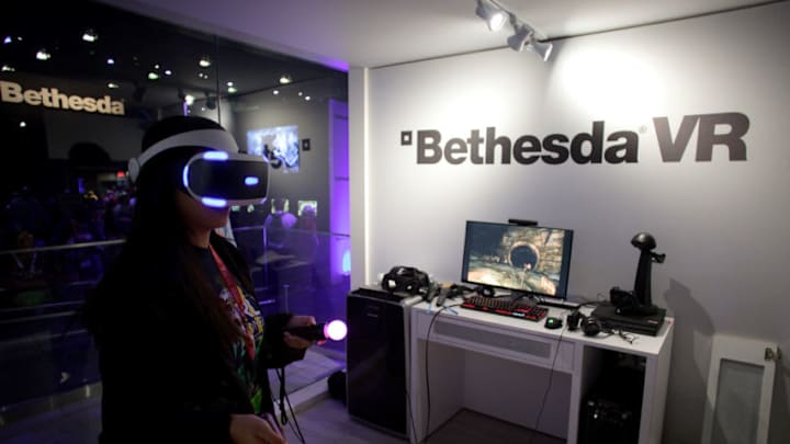 An attendee wears a virtual reality (VR) headset while playing the Bethesda Softworks LLC 'The Elder Scrolls V: Skyrim' video game inside the company's VR booth during the E3 Electronic Entertainment Expo in Los Angeles, California, U.S., on Wednesday, June 14, 2017. For three days, leading-edge companies, groundbreaking new technologies and never-before-seen products is showcased at E3. Photographer: Troy Harvey/Bloomberg via Getty Images