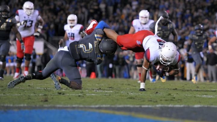 Nov 1, 2014; Pasadena, CA, USA; Arizona Wildcats running back Trey Griffey (5) dives forward while tackled by UCLA Bruins defensive back Jaleel Wadood (2) during the fourth quarter at Rose Bowl. Mandatory Credit: Jake Roth-USA TODAY Sports