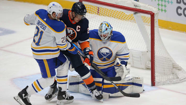 Mar 6, 2021; Uniondale, New York, USA; Buffalo Sabres goalie Carter Hutton (40) makes a save in front of New York Islanders center Anders Lee (27) and Sabres right wing Kyle Okposo (21) during the first period at Nassau Veterans Memorial Coliseum. Mandatory Credit: Brad Penner-USA TODAY Sports