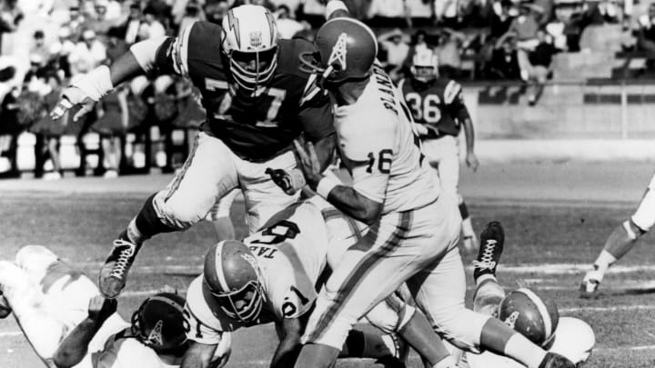 San Diego Chargers defensive tackle Ernie Ladd (77) gets to Houston Oilers quarterback George Blanda (16), inducted into the Pro Football Hall of Fame class of 1981, a split-second late during a 27-0 Chargers victory on December 1, 1963, at Balboa Stadium in San Diego, California. (Photo by Charles Aqua Viva/Getty Images)