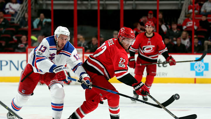 RALEIGH, NC – NOVEMBER 22: Brett Pesce #22 of the Carolina Hurricanes and Kevin Hayes #13 of the New York Rangers make an attempt at the puck during an NHL game on November 22, 2017 at PNC Arena in Raleigh, North Carolina. (Photo by Gregg Forwerck/NHLI via Getty Images)