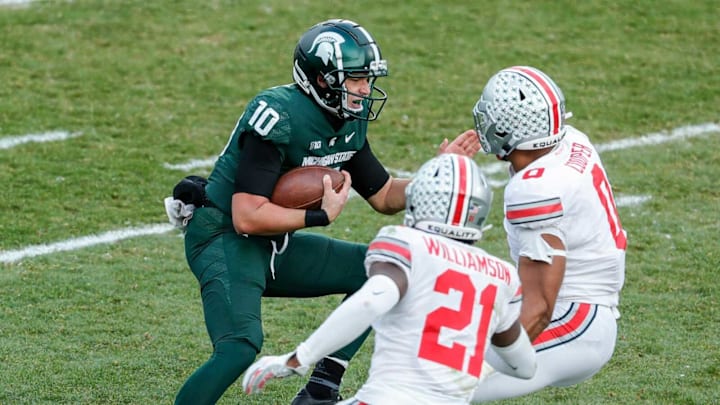 Michigan State quarterback Payton Thorne (10) runs against Ohio State cornerback Marcus Williamson (21) and defensive end Jonathon Cooper (0) during the second half at the Spartan Stadium in East Lansing on Saturday, Dec. 5, 2020.