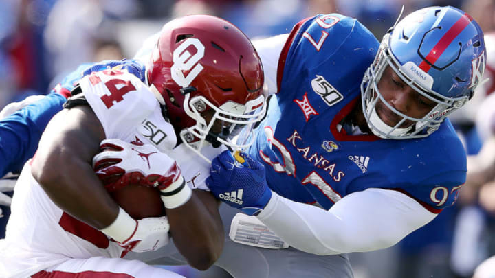LAWRENCE, KANSAS - OCTOBER 05: Defensive end Darrius Moragne #97 grabs the facemask of running back Marcus Major #24 of the Oklahoma Sooners during the game at Memorial Stadium on October 05, 2019 in Lawrence, Kansas. (Photo by Jamie Squire/Getty Images)