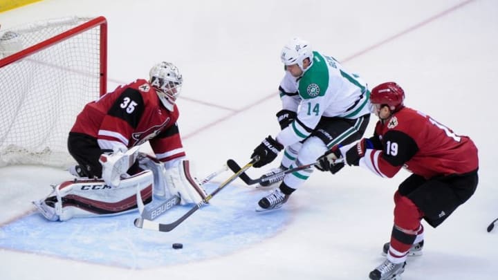 Mar 24, 2016; Glendale, AZ, USA; Arizona Coyotes goalie Louis Domingue (35) makes a save against Dallas Stars left wing Jamie Benn (14) as right wing Shane Doan (19) defends during the first period at Gila River Arena. Mandatory Credit: Matt Kartozian-USA TODAY Sports