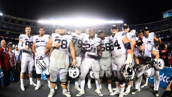 Dec 21, 2016; San Diego, CA, USA; Brigham Young Cougars running back Jamaal Williams (21) and teammates hold the championship trophy during the 2016 Poinsettia Bowl against the Wyoming Cowboys at Qualcomm Stadium. BYU defeated Wyoming 24-21. Mandatory Credit: Kirby Lee-USA TODAY Sports
