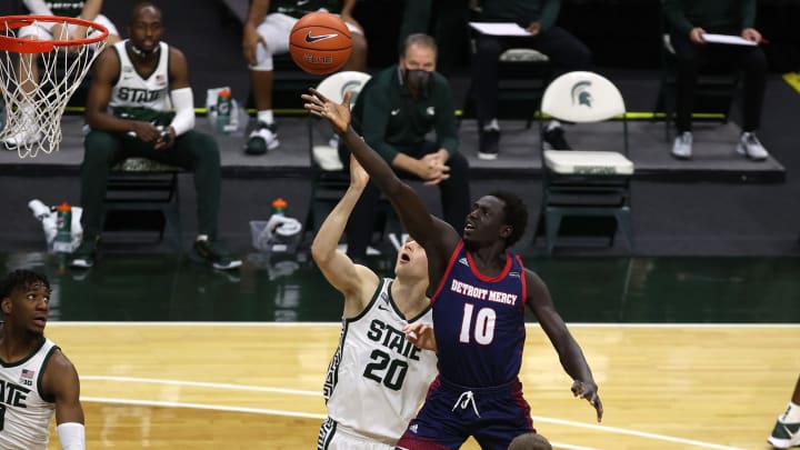 EAST LANSING, MICHIGAN – DECEMBER 04: Bul Kuol #10 of the Detroit Titans drives to the basket against Joey Hauser #20 of the Michigan State Spartans during the first half at Breslin Center on December 04, 2020 in East Lansing, Michigan. (Photo by Gregory Shamus/Getty Images)